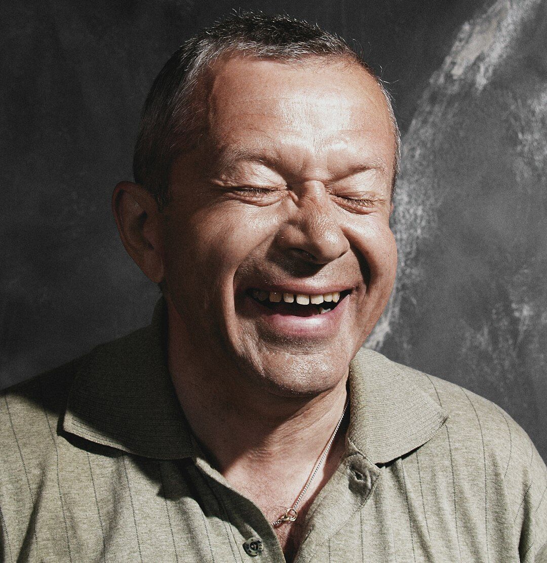 Portrait of a friendly older man club coordinator smiling